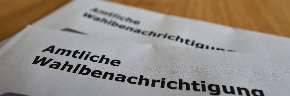 Closeup view of two letters with official polling cards (in German on envelope: "amtliche Wahlbenachrichtigung") for the parliamentary elections (Bundestag) in 2021.