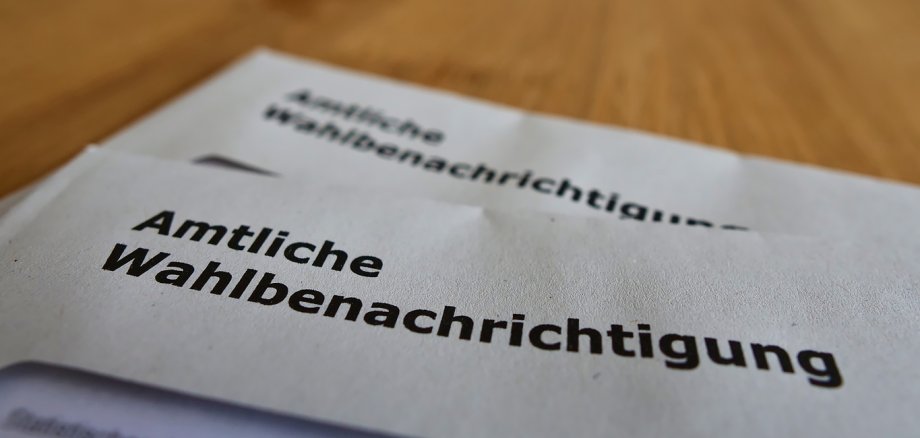 Closeup view of two letters with official polling cards (in German on envelope: "amtliche Wahlbenachrichtigung") for the parliamentary elections (Bundestag) in 2021.