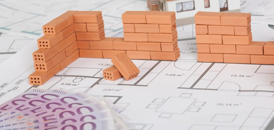 Model house construction with brick on blueprint and five hundred euro banknote