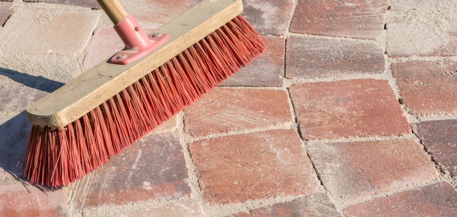 Paved walkway is grouted with fine-grained sand and a broom