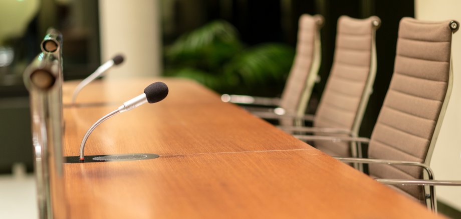 Isolated view of a microphone in the front of a conference room among blurred other mikes in the background