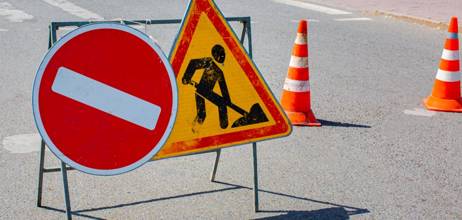 Road construction stop and triangle signs on asphalt